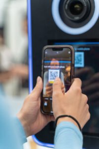 Guest scanning a QR code on a Selfie Station to instantly receive photo booth photos from a modern photo booth design with contactless sharing.