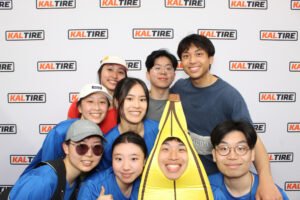 Group posing with a banana costume in front of a branded photo booth backdrop at a Kal Tire activation, creating fun photo booth photos.