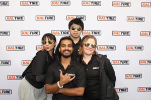 Kal Tire team posing in front of a custom-branded photo booth backdrop during the Vancouver Sun Run, captured in vibrant photo booth photos.