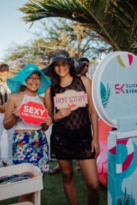 Guests pose with tropical photo booth props at a beach event using a Vancity Selfie Station.
