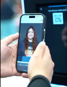 Person viewing their AI headshot photo booth image on a smartphone, instantly delivered via QR code at a photo booth rental station.
